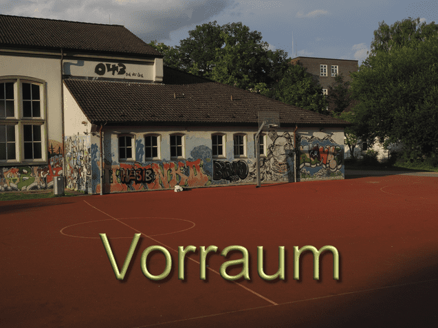 Graffiti-bedeckte Wand eines Schulgeb&auml;udes an einem Sportplatz mit rotem Belag und Basketballkorb.