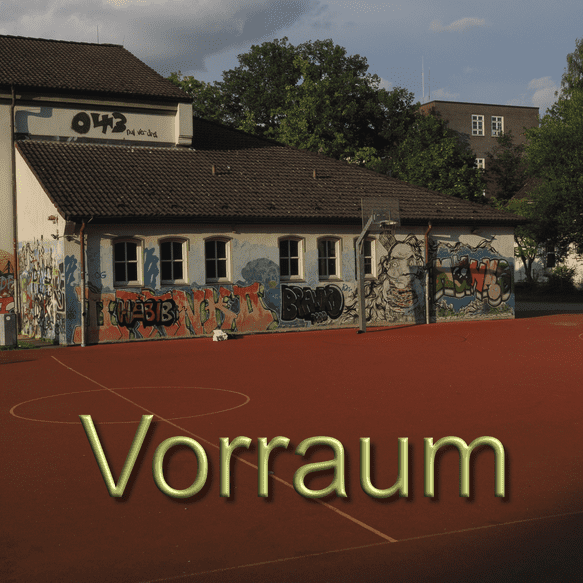 Graffiti-bedeckte Wand eines Schulgeb&auml;udes an einem Sportplatz mit rotem Belag und Basketballkorb.