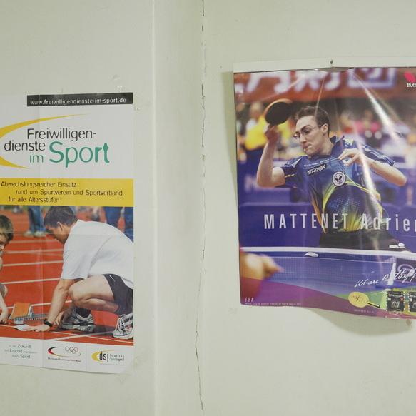 Zwei Plakate an einer Wand: eines informiert &uuml;ber Freiwilligendienste im Sport, das andere zeigt einen Tischtennisspieler.