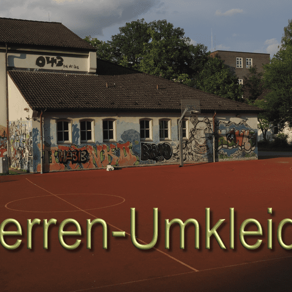 Herrenumkleide an einem Sportplatz, umgeben von bunten Graffiti und einer roten Spielfl&auml;che.