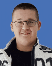 Porträt eines jungen Mannes mit Brille und kurzer Frisur vor einem blauen Hintergrund, trägt eine weiße Jacke.