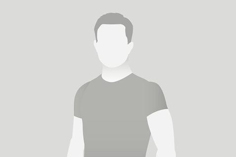 Die Silhouette eines Mannes steht auf grauem Hintergrund, Gesicht nicht sichtbar, trägt ein schlichtes T-Shirt.