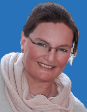 Eine Frau mit Brille und einem hellen Schal lächelt vor einem blauen Hintergrund.