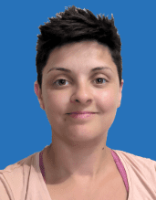 Porträt einer Person mit kurzem, dunklem Haar und Smiley-Mund, vor blauem Hintergrund.